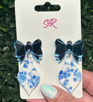 Classic blue and white toile ornament dangle earrings with a mirrored blue bow top. A classy holiday accessory that’s hypoallergenic and nickel-free.