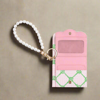 Lilly Pulitzer Butterfly Trellis snap card case with a scalloped envelope opening, card slots, a cash pocket, gold hardware, and a pearl wrist strap.