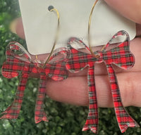 Holiday-ready red, white, and black acrylic bow dangle earrings on a gold hoop. Lightweight, hypoallergenic, and nickel-free—perfect for festive styling.