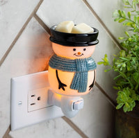 Adorable snowman pluggable fragrance warmer with rotating base. Ideal for small spaces, adds festive glow and scent—bulb included, flame-free.