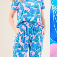 Slip into comfort with our Alli Pajamas, the perfect blend of cozy and cute. This two-piece set features a short sleeve V-neck top and long pants with a 27” inseam. Designed with an elastic waistband, adjustable drawstring, and side pockets, these pajamas are made from a soft, stretchy blend of 94% polyester and 6% spandex—giving you that just-right feel for lounging or bedtime.