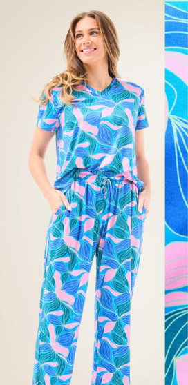 Slip into comfort with our Alli Pajamas, the perfect blend of cozy and cute. This two-piece set features a short sleeve V-neck top and long pants with a 27” inseam. Designed with an elastic waistband, adjustable drawstring, and side pockets, these pajamas are made from a soft, stretchy blend of 94% polyester and 6% spandex—giving you that just-right feel for lounging or bedtime.