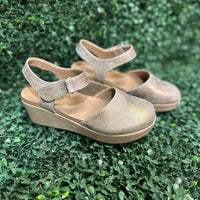 wedge in shimmering rose gold metallic. Featuring lightweight EVA cushioning and a secure Velcro ankle strap, these stylish wedges absorb impact for effortless wear