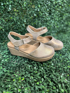 wedge in shimmering rose gold metallic. Featuring lightweight EVA cushioning and a secure Velcro ankle strap, these stylish wedges absorb impact for effortless wear