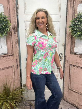 Pink Citrus Bloom Front Zip Polo with white collar trim, gold zipper, short sleeves, UPF50+ sun protection, & wrinkle-free fabric.

Features a floral print with Lime and Lemon detail throughout the polo. 