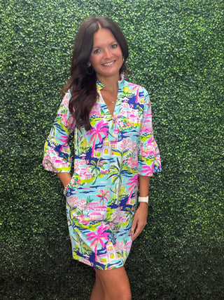 Print | Island Daydream — pastel tropical scene with palm trees, flamingos, and island architecture
Neckline | Collared V-neckline
Sleeves | Quarter sleeves with flounced bell cuffs
Silhouette | Shift dress
Length | Above the knee
Fabric | 60% Nylon, 40% Spandex — lightweight with a comfortable stretch
Sun Protection | UPF 50+
Brand | Aryeh