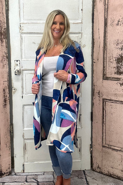 Wrap yourself in warmth and style with the Bailey Cardigan, showcasing a beautiful sunset mosaic print that adds a pop of color to any outfit. Made from a cozy and flexible blend of 85% polyester, 10% viscose, and 5% spandex, this cardigan offers softness and stretch for comfortable layering all day long.