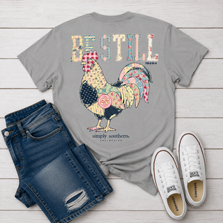 heather gray graphic t-shirt featuring a colorful patchwork rooster and the text 'BEST STILL' and 'simply southern. COLLECTIONS.