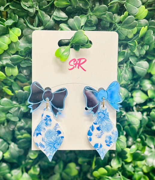 Classic blue and white toile ornament dangle earrings with a mirrored blue bow top. A classy holiday accessory that’s hypoallergenic and nickel-free.