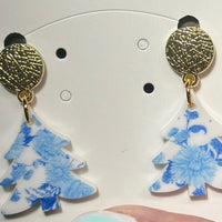 Timeless with a touch of festive flair, these Blue and White Toile Christmas Tree Dangle Earrings bring elegance to your holiday look. Featuring a classic toile pattern in blue and white, topped with a shiny blue mirrored bow, they’re the perfect accessory for a sophisticated seasonal statement. Lightweight, hypoallergenic, and nickel-free for all-day comfort.

