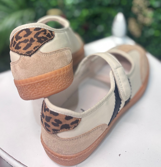 Meet the sneaker that makes everyday outfits feel instantly more pulled together. The Corkys Calm Down Mary Jane features a soft Sand Combo palette with creamy ivory panels, warm sand-toned texture, and a playful leopard-print accent at the heel. A tan sole grounds the look, while the classic Mary Jane strap keeps the silhouette feminine and easy to wear.