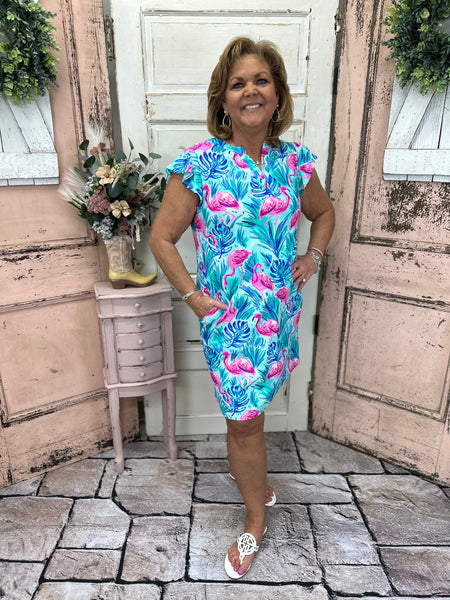 Turn heads in the Cambria Shift Dress - Flamingo Paradise! Featuring a V-neck, cap sleeves, and a comfy stretch fit, this vibrant dress is perfect for any occasion.