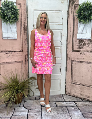 The Lulu-B Cha Cha Dress in the PTPK print features a dreamy pink palm tree pattern that brings effortless resort energy to every wear — front and back ruffles, a scoop neckline, and a straight hemline give it a flirty, feminine silhouette that flatters every shape and looks just as stunning at brunch as it does on the beach.