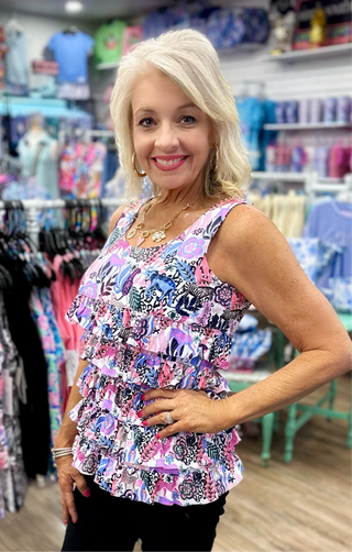 The Lulu-B Cha Cha Tank in the JTMU print features a playful black, white, pink, and periwinkle pattern with hidden animals woven throughout — front and back ruffles and a scoop neckline add a flirty, feminine finish to a print that gets more charming the closer you look.