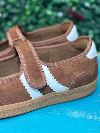 a sporty silhouette with a velcro mary jane strap, squishy footbed, and rich chestnut suede detailing