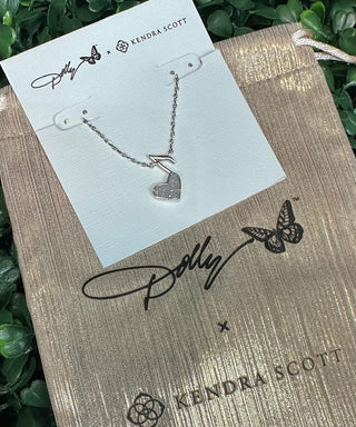 The pendant features a stunning iridescent drusy heart that shimmers with multidimensional sparkle, beautifully framed in a vintage silver finish. The music note accent pays tribute to Dolly’s legendary influence, making this necklace the perfect piece for music lovers and fans of timeless Southern charm.