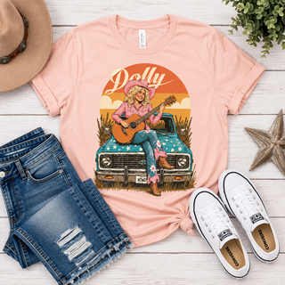 Hit the road in Southern style. This vintage-inspired tee puts a country-cool spin on Dolly's iconic look — equal parts nostalgic and effortlessly wearable, whether you're headed to the feed store or the front row.

Fabric &amp; Fit | Comfort Colors garment-dyed tee, soft-washed for a broken-in feel
Neckline | Classic crew neck
Sleeve | Short sleeve
Fit | Relaxed, unisex fit
Graphic | Retro Dolly truck graphic with vintage-inspired print