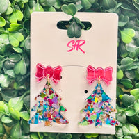 Add a pop of color to your holiday look with these Blue Shred Confetti Acrylic Christmas Tree Dangle Earrings! Featuring a vibrant blue confetti tree and topped with a playful pink mirrored bow, this pair brings a fresh, fun twist to classic Christmas style. Lightweight, hypoallergenic, and nickel-free—perfect for merry-making all season long.

