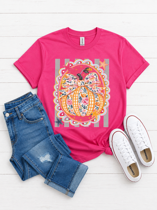 A bright pink graphic t-shirt featuring a colorful pumpkin  (gingham & floral print) and floral bow design