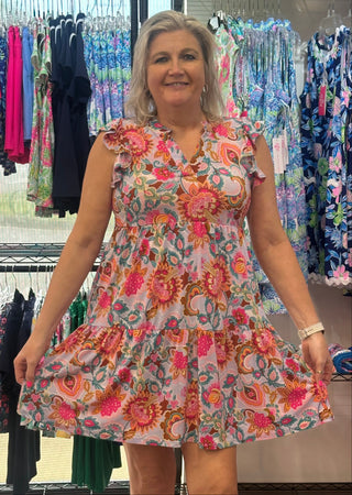 Effortlessly feminine from hem to flutter. This tiered dress features a multi-color floral print from top to bottom, with delicate flutter sleeves that add a breezy, romantic touch — the kind of dress that turns heads without trying.