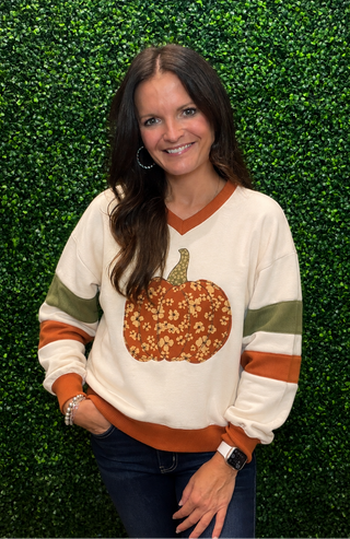 Graphic | Floral pumpkin print — festive and feminine
Neckline | Flattering V-neckline with contrast rib trim
Sleeves | Long sleeve with sporty striped accents
Fit | Relaxed, comfortable silhouette
Fabric | Soft sweatshirt knit