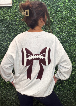 Color | Gray Pearl
Pattern | Three Football Bows (front) + One Oversized Bow (back)
Embroidery | Football bow motifs, front and back
Neckline | Mock neck
Sleeves | Long sleeve
Fit | Relaxed
Fabric | 65% Polyester, 35% Cotton
Feel | Soft, cozy poly-cotton blend
Care | Machine wash cold, tumble dry low