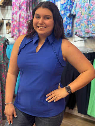 Classic polo structure, reimagined for warm weather. The Genesis Sleeveless Polo in Royal Blue pairs a polished collar V-neck with delicate ruffle detail at the underarms — a feminine touch that sets it apart from the standard. Cooling UPF50+ fabric keeps you protected and comfortable, while the lightweight, wrinkle-resistant construction makes it a reliable go-to from the golf course to the patio.