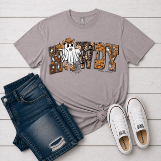 taupe gray graphic t-shirt featuring the word 'HOWDY' in autumn-themed patterns with a ghost and pumpkin design. Ghost wearing cowboy boots and hat is replacing the letter O in howdy