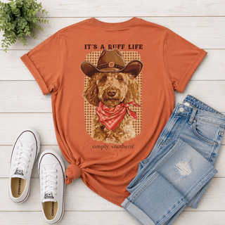 Back Graphic | Golden doodle in cowboy hat and red bandana with "It's a Ruff Life" saying
Color | Rust
Neckline | Crew neck
Sleeve | Short sleeve
Fabric | 100% Cotton — soft, breathable, and easy to care for
Brand | Simply Southern
