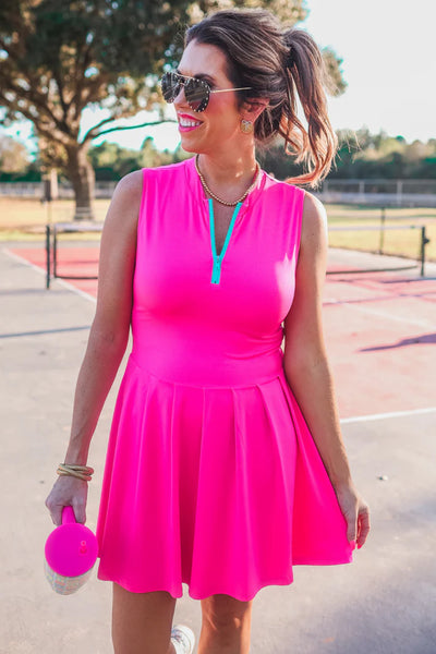 Elevate your game with the Pep Squad Tennis Dress in pink. Featuring a colorful contrasting front zipper, this dress combines style and sport to keep you comfortable and fashionable on the court. Stay on top of your game with this must-have piece.

