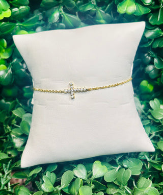 Kendra Scott gold delicate chain bracelet with white crystal cross charm.