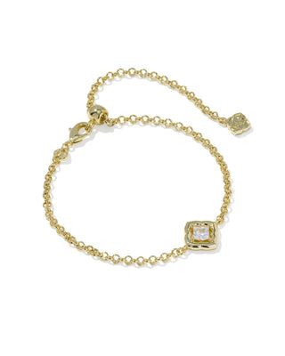 A delicate gold chain bracelet with an adjustable lobster clasp, a small square bezel-set clear gemstone, and a small gold flower charm