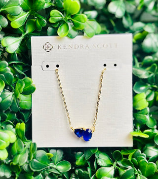 Tatum Gold Short Pendant Necklace featuring Elisa shape and trillion-cut September birthstone-inspired stone (dark blue color stone) on delicate gold chain.
