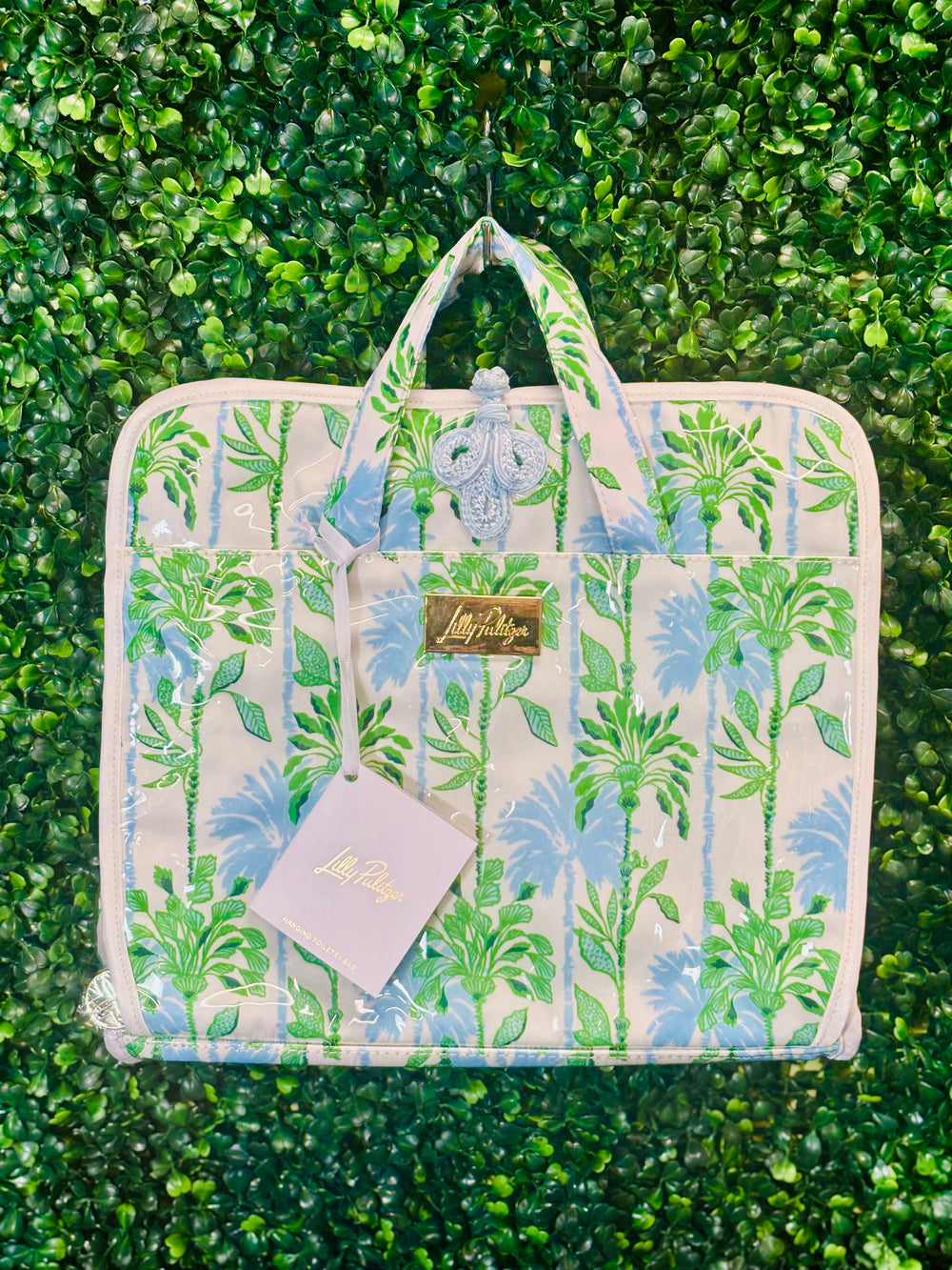 Stay organized and chic on your next getaway with the Lilly Pulitzer Swayin’ in the Breeze Hanging Toiletry Bag. Inspired by coastal breezes, this bag features a durable coated canvas exterior that’s easy to clean, making it perfect for beach trips, weekend retreats, or everyday travel.

Inside, a thoughtfully designed layout includes two interior PVC slip pockets, one mesh zip pocket, and a spacious main compartment with two additional mesh pockets, keeping all your essentials perfectly organized.