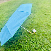 Let every rainy day feel like a walk by the shore with our travel umbrella, designed to bring coastal charm wherever the weather takes you. The sleek hydrangea blue canopy offers classic elegance, while the inside reveals our signature Swayin’ in the Breeze pattern. A bamboo-textured hook handle adds a natural, beachy touch, blending beauty and function in every detail. Whether protecting yourself from the sun or showers, this umbrella will help you do it in style.
