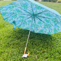 Let every rainy day feel like a walk by the shore with our travel umbrella, designed to bring coastal charm wherever the weather takes you. The sleek hydrangea blue canopy offers classic elegance, while the inside reveals our signature Swayin’ in the Breeze pattern. A bamboo-textured hook handle adds a natural, beachy touch, blending beauty and function in every detail. Whether protecting yourself from the sun or showers, this umbrella will help you do it in style.
