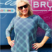 Stay stylish and protected in the Lulu-B Asymmetrical Top, crafted from a stretchy nylon-spandex blend. This flattering scoop-neck top features 3/4 sleeves and a chic asymmetrical hemline. With built-in UPF 50 sun protection and pre-shrunk fabric, it's perfect for sunny days, travel, or everyday wear—easy, polished, and effortlessly comfortable.

