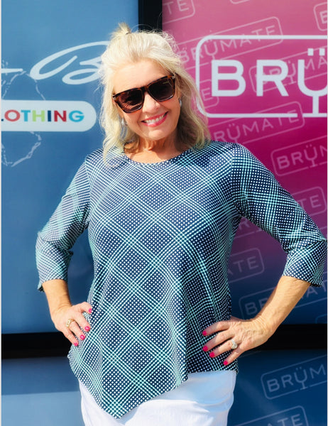 Stay stylish and protected in the Lulu-B Asymmetrical Top, crafted from a stretchy nylon-spandex blend. This flattering scoop-neck top features 3/4 sleeves and a chic asymmetrical hemline. With built-in UPF 50 sun protection and pre-shrunk fabric, it's perfect for sunny days, travel, or everyday wear—easy, polished, and effortlessly comfortable.


