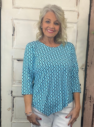 Stay stylish and protected in the Lulu-B Asymmetrical Top, crafted from a stretchy nylon-spandex blend. This flattering scoop-neck top features 3/4 sleeves and a chic asymmetrical hemline. With built-in UPF 50 sun protection and pre-shrunk fabric, it's perfect for sunny days, travel, or everyday wear—easy, polished, and effortlessly comfortable.