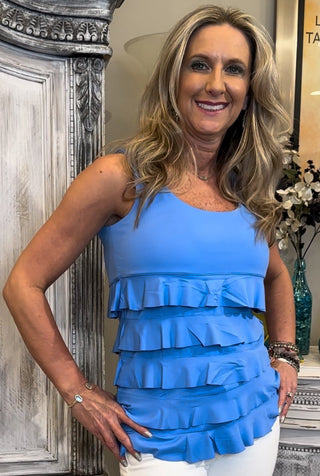 The Lulu-B Cha Cha Tank in Bright Periwinkle is crafted from soft, stretchy fabric with front and back ruffles that bring a playful, feminine charm to any outfit — that bright, blue-violet hue is fresh and unexpected, making it a standout piece in your warm-weather wardrobe.