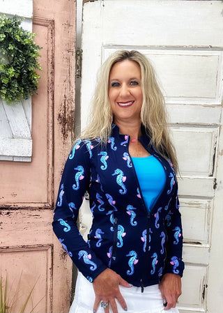 The Lulu-B Full Zip Jacket in Navy Seahorse features a whimsical seahorse print on a classic navy base — a mock neck collar, two-way zipper, and contrast stitching at the seams give it a refined, athletic-inspired finish that works just as well over a matching set as it does thrown over jeans for a casual day out.