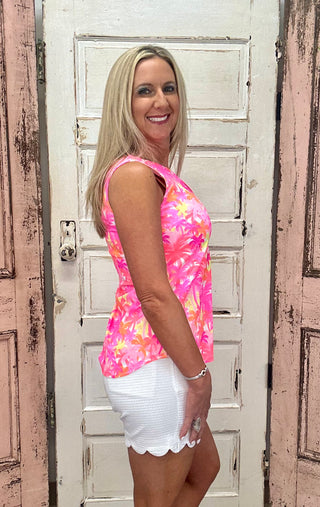 The Sleeveless Keyhole Top in the Palm Tree print features a bold pink, orange, and yellow palm tree design with a V-style neckline and delicate keyhole detail — that warm, sun-drenched print brings an instant resort energy to any warm-weather outfit, whether you're poolside or out for brunch.