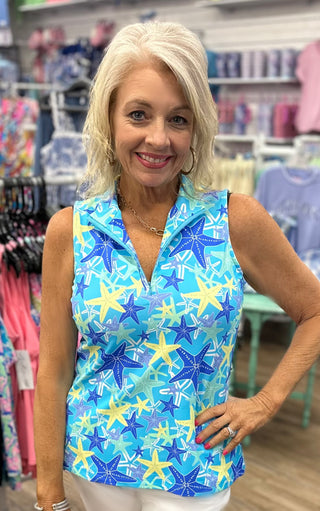 The Sleeveless Zip Top in the Starfish print features a vibrant turquoise base with yellow and blue starfish details and a quarter-zip neckline that makes it as easy to style as it is to wear — lightweight, cooling fabric and UPF 50 protection make it the perfect top for active days, outdoor adventures, or casual warm-weather outings.