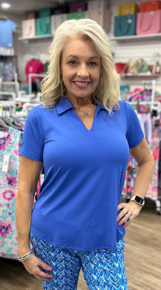The Lulu-B V-Neck Short Sleeve Collar Top in Deep Sea is crafted from butter-soft, wrinkle-free fabric in a deep, saturated blue hue — a polished collar detail, V-neckline, and UPF 50+ protection give it an elevated, sophisticated look that transitions effortlessly from brunch to sightseeing to a dressed-up evening out. Lightweight and breathable, it packs without creasing so you always step out looking fresh, no matter where the day takes you.