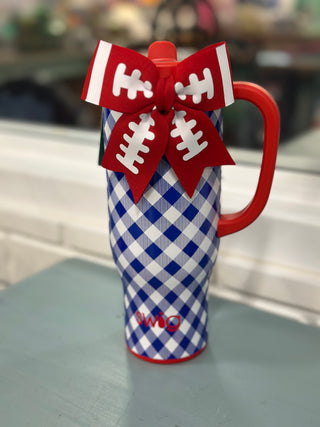 A football-themed insulated tumbler with a blue and white gingham pattern, a red handle, and a red bow decorated like a football with white laces