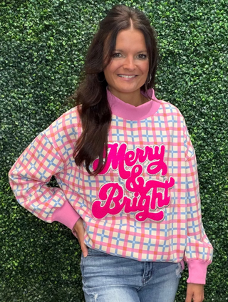 a pink and light blue gingham sweatshirt with 'Merry & Bright' in bright pink script across the chest