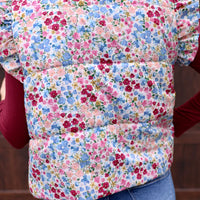 This puffer vest features a gorgeous floral pattern and playful ruffle sleeves, making it the perfect choice for those looking to add a touch of color to their outfit. Don't miss out on this must-have item!