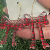 Holiday-ready red, white, and black acrylic bow dangle earrings on a gold hoop. Lightweight, hypoallergenic, and nickel-free—perfect for festive styling.