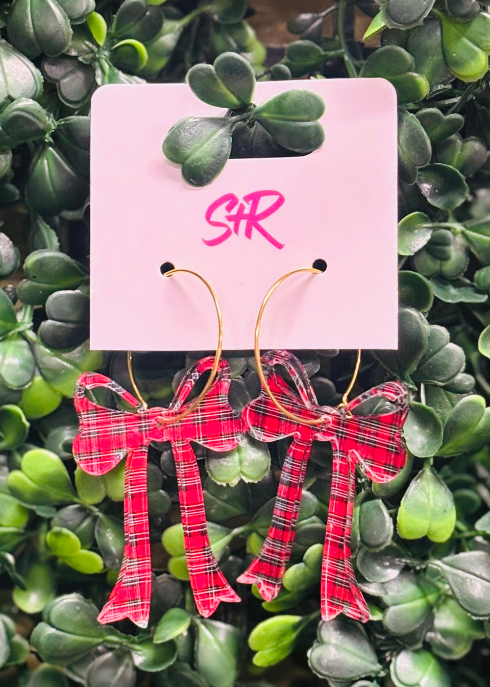 Holiday-ready red, white, and black acrylic bow dangle earrings on a gold hoop. Lightweight, hypoallergenic, and nickel-free—perfect for festive styling.