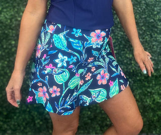 Fresh, flirty, and made for sunny days, the Rosario Ruffle Skort in Navy Tropical Forest blends feminine style with performance comfort. A lush tropical print and playful ruffle hem add effortless polish and easy movement — whether you’re strolling a boardwalk, catching a flight, or spending the day outdoors in style.